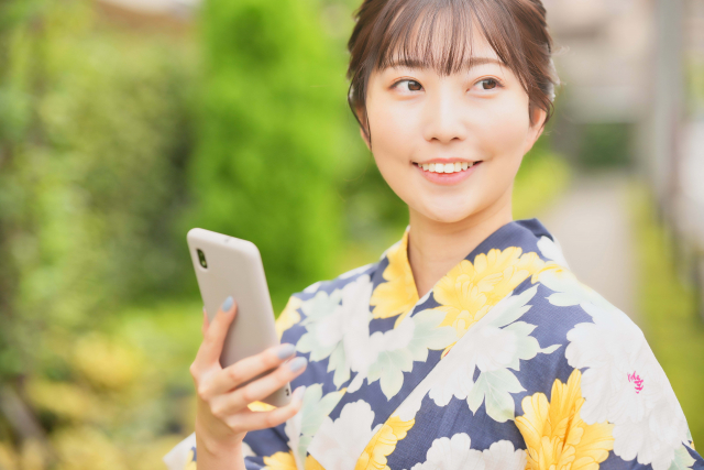 スマホを持っている着物女性